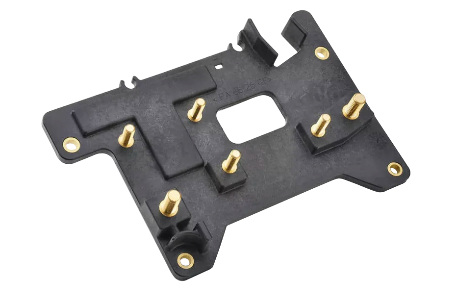 Black molded component with integrated brass inserts