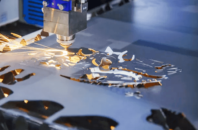 Laser cutting a metal sheet with visible sparks