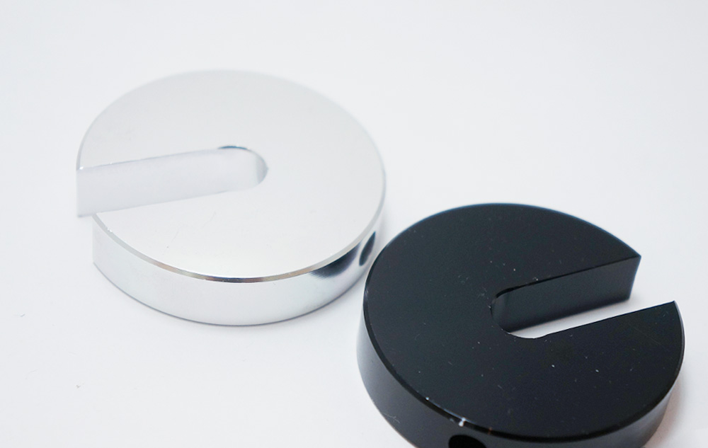 Silver and black anodized aluminum disc parts with smooth precision-machined surfaces